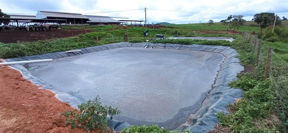 Lagoa impermeabilizada com lona para o tratamento da água de lavagem do piso da sala de ordenha.